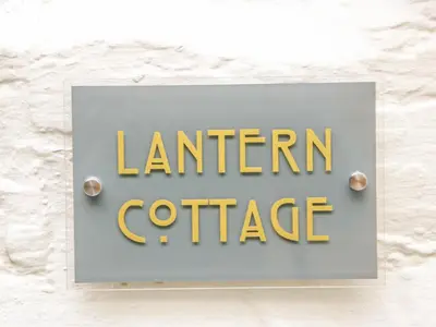 a sign for a lantern office on a wall at Lantern Cottage in Padstow
