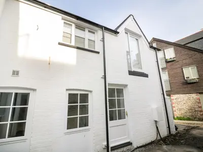 a white brick house with a white door at Fishermans Loft in Mevagissey