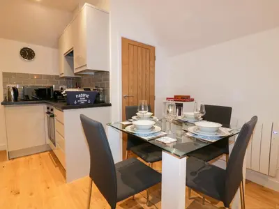 a dining room with a table and chairs in a kitchen at Fishermans Loft in Mevagissey