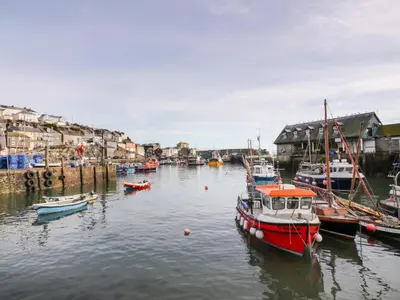 a group of boats are docked in a harbor at Fishermans Loft in Mevagissey