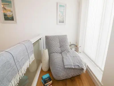 a living room with a couch and a window at Fishermans Loft in Mevagissey