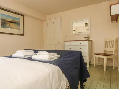 a bedroom with a bed with towels on it at Oreo's Cottage in St. Agnes