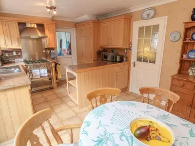 a kitchen with a table with a bowl of fruit on it at Phenests in Falmouth