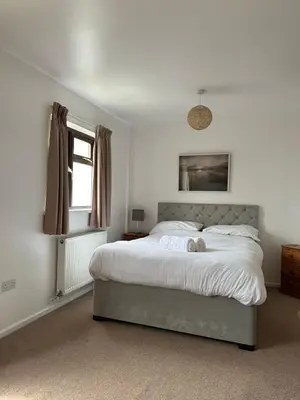 a bedroom with a large bed and a window at Wheal Frances-Beautifully Fitted Bungalow Helston Cornwall in Helston