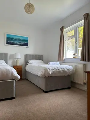 a bedroom with two beds and a window at Wheal Frances-Beautifully Fitted Bungalow Helston Cornwall in Helston