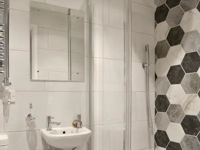 a white bathroom with a sink and a shower at Treen in Lansallos