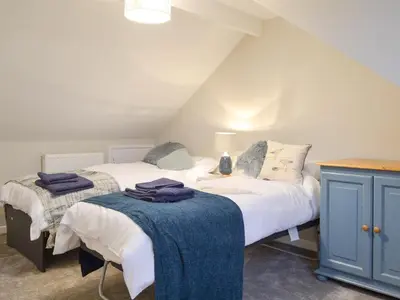 two beds in a attic bedroom with a blue cabinet at Treen in Lansallos