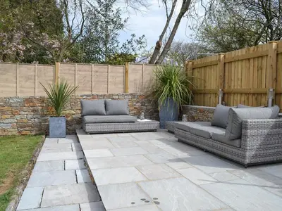 a patio with two couches and a fence at Littlewood in Saint Columb Major