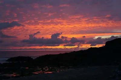 a sunset over the ocean with clouds in the sky at 29 @ One Lusty Glaze in Newquay