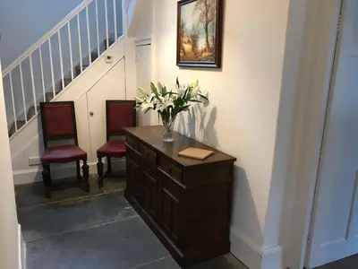 a vase of flowers on a dresser in a hallway at Park Farmhouse Bed and Breakfast in Washaway