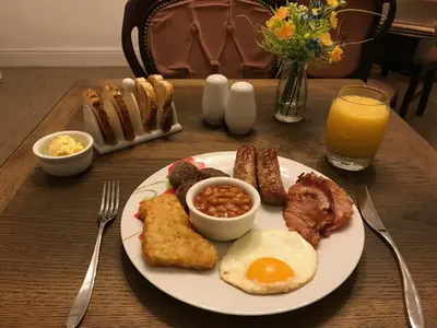 a plate of breakfast food with eggs sausage and beans at Park Farmhouse Bed and Breakfast in Washaway