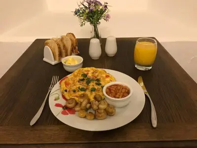 a breakfast tray with an omelet and a plate of food at Park Farmhouse Bed and Breakfast in Washaway