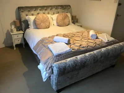 a large bed with pillows and towels on it at Park Farmhouse Bed and Breakfast in Washaway