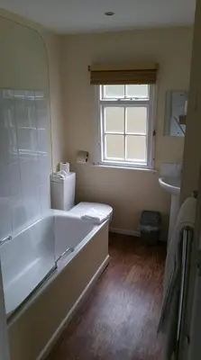 a bathroom with a tub and a sink and a window at The Mill House in Tintagel