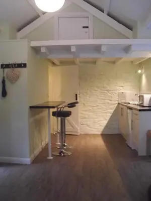 a kitchen with a table in the middle of a room at The Mill House in Tintagel