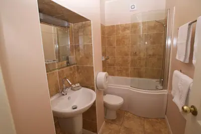 a bathroom with a sink and a toilet and a shower at Chynoweth Lodge in Newquay