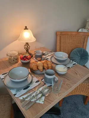 a table with plates and bowls of food on it at Chynoweth Lodge in Newquay