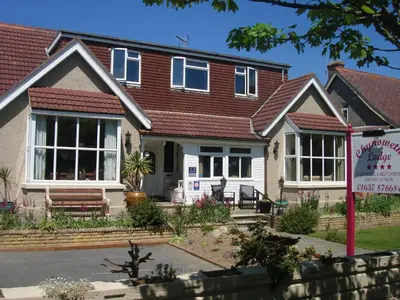 a house with a sign in front of it at Chynoweth Lodge in Newquay