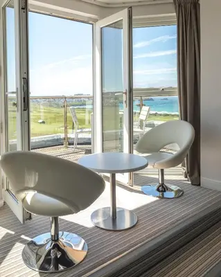 two chairs and a table in front of a large window at Oceanside Lifestyle Hotel in Newquay