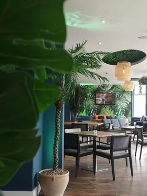 a plant in a room with tables and chairs at Oceanside Lifestyle Hotel in Newquay