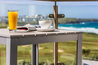 a glass of orange juice sitting on a table with a drink at Oceanside Lifestyle Hotel in Newquay