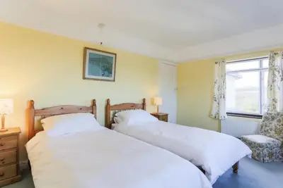 a bedroom with two beds and a window at Chy-an-Lowena in Crantock