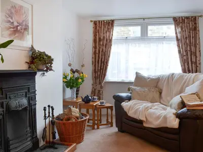 a living room with a couch and a fireplace at Bridgend Cottage in Lostwithiel