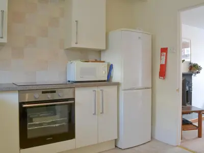 a kitchen with a white refrigerator and a microwave at Bridgend Cottage in Lostwithiel