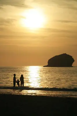 a family walking on the beach at sunset at The Roundhouse in Redruth