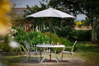 a white table with two chairs and an umbrella at The Roundhouse in Redruth