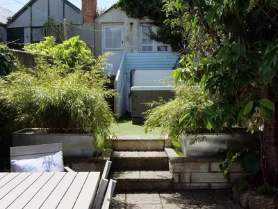 a garden with stairs and potted plants and a house at Waves End, St Ives, Hot tub and Parking in St Ives