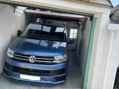 a van is parked inside of a garage at Waves End, St Ives, Hot tub and Parking in St Ives
