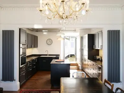 a kitchen with a dining table and a chandelier at Waves End, St Ives, Hot tub and Parking in St Ives