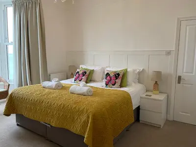 a bedroom with a bed with butterfly pillows on it at Waves End, St Ives, Hot tub and Parking in St Ives
