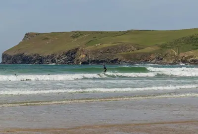 a person riding a wave on a surfboard in the ocean at 12 Westward Flats in Polzeath