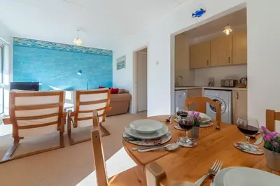 a kitchen and dining room with a table and chairs at 12 Westward Flats in Polzeath
