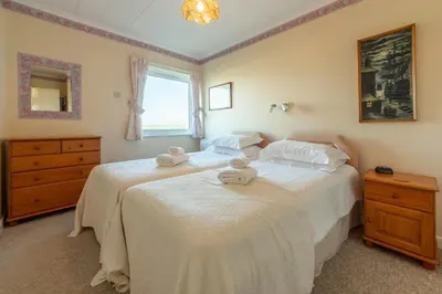 two twin beds in a bedroom with a window at 12 Westward Flats in Polzeath