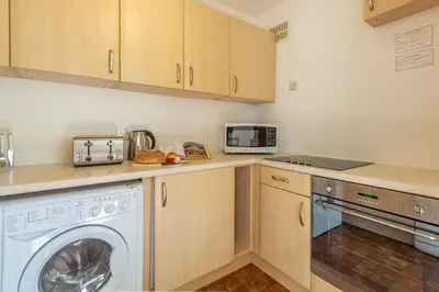 a kitchen with a washing machine and a microwave at 12 Westward Flats in Polzeath