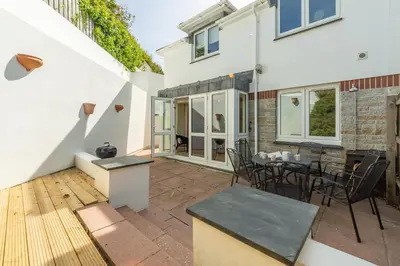 a patio of a house with a table and chairs at 4 Pentire Rocks in Polzeath