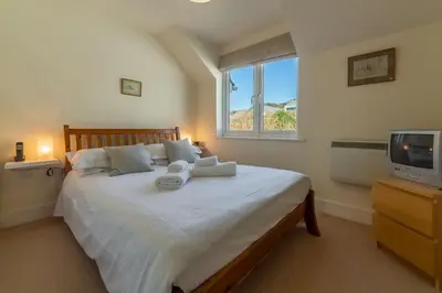 a bedroom with a large bed and a television at 4 Pentire Rocks in Polzeath