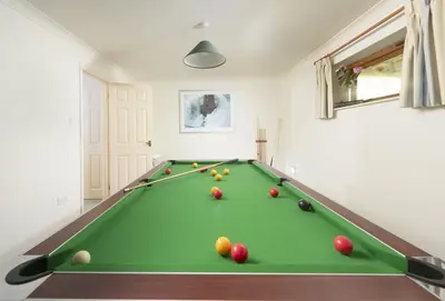 a pool table with balls on it in a room at Keepers Cottage in Wadebridge