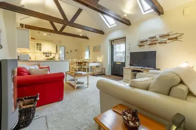 a living room with a couch and a tv at Little Gull in Polzeath