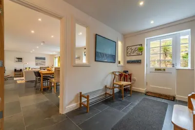 a dining room with a table and chairs and a window at No2 The Fish Cellars in Port Isaac