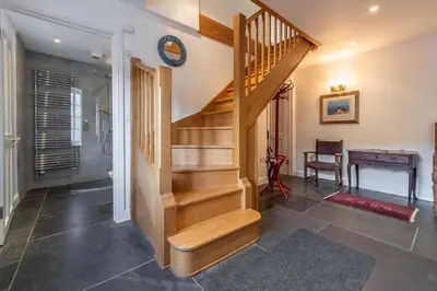 a staircase in a living room with a table at No2 The Fish Cellars in Port Isaac