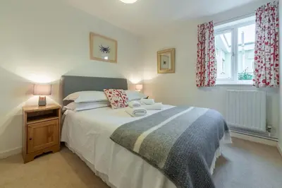 a bedroom with a large bed and a window at Palm Trees in Polzeath