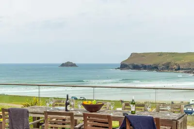 a table with a view of the beach and the ocean at Pentewan in Polzeath