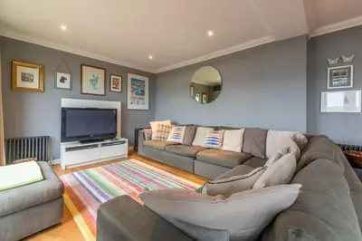 a living room with a couch and a flat screen tv at Pentewan in Polzeath