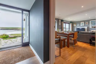 a dining room and living room with a view of the ocean at Pentewan in Polzeath