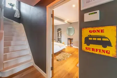 a door with a gone surfing sign in a room at Pentewan in Polzeath