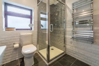 a bathroom with a toilet and a glass shower at Pentewan in Polzeath
